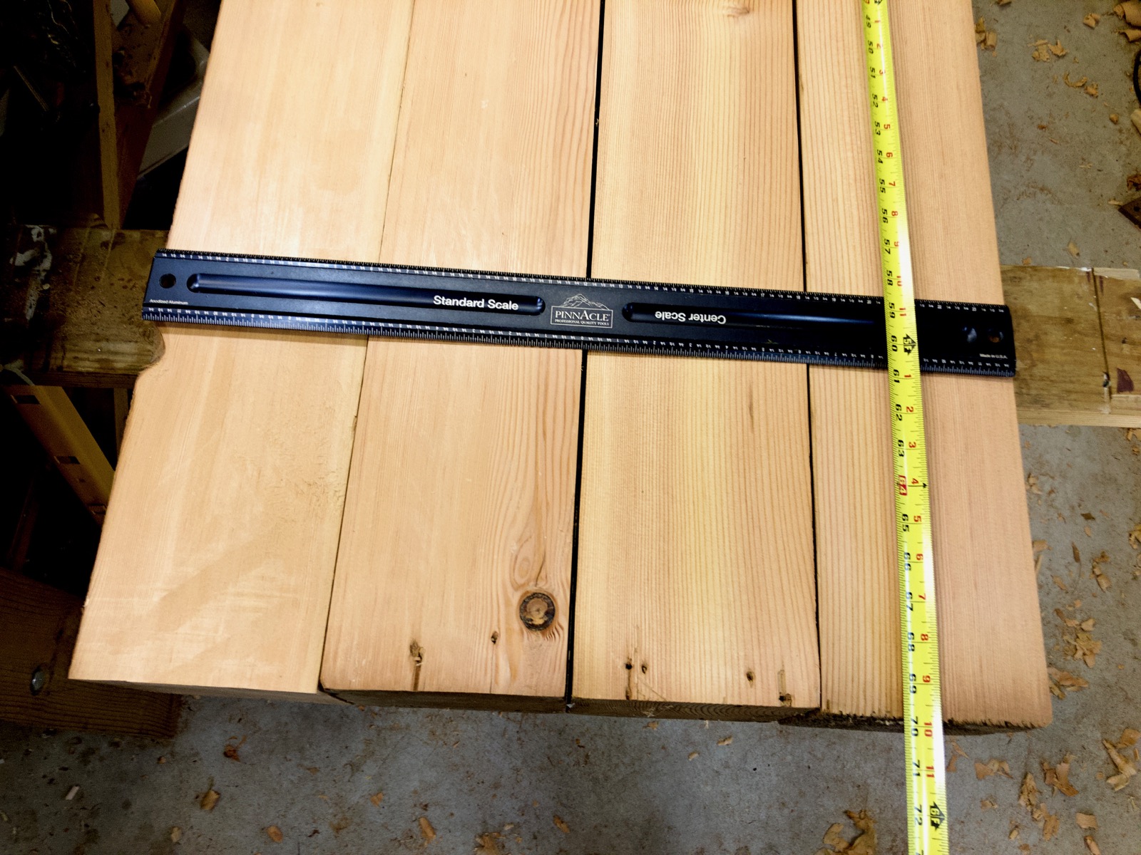 Four beams with a ruler and tape measure on them.