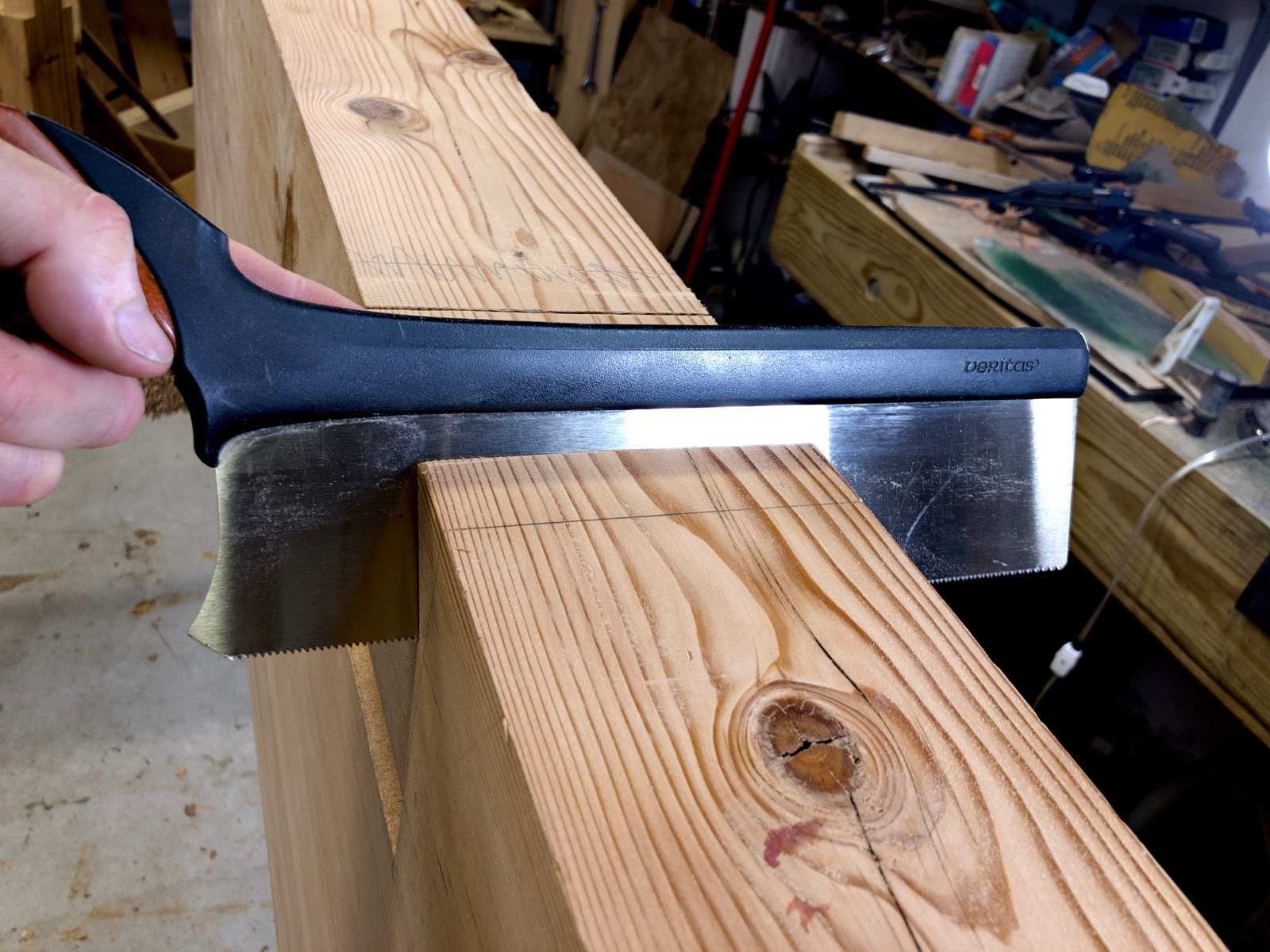 The saw has cut one angled side of the joint.